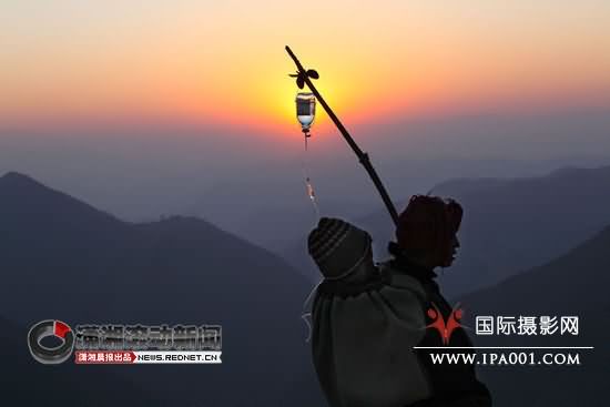 (2010年1月4日下午18时17分，在四川省美姑县黄茅埂，赵培源拍摄的一位妇女背着输液的儿子正赶回家的照片获得了第七届国际摄影比赛（华赛）日常生活类新闻银奖。)