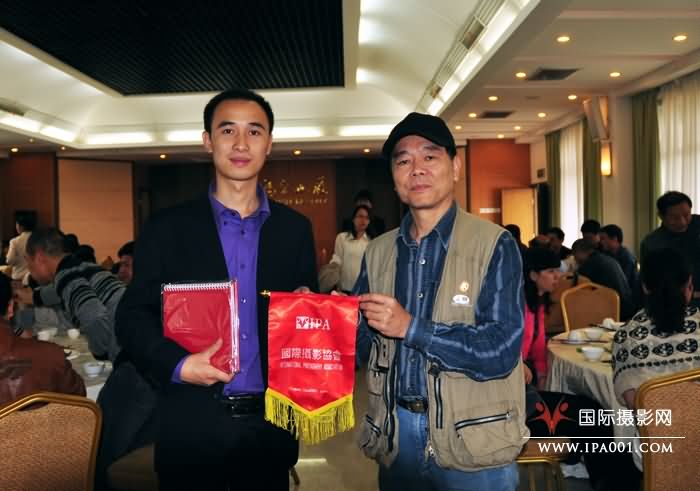 国际摄影协会副主席林伟球（右）向摄影活动主办方赠送礼品.jpg
