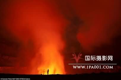 科考队员站在火山口边缘观察火山活动