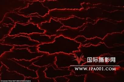 熔岩湖的表面冷却后呈现黑色，但依旧能看到下面流动的红色熔岩